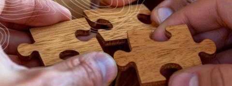 hands and wooden puzzle pieces